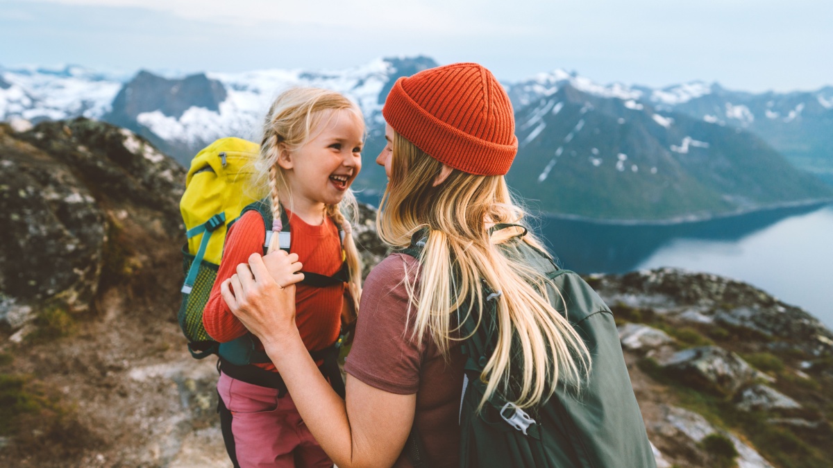 Mother hiking with daughter in Norway mountains travel together family time healthy lifestyle active vacations woman playing with child Mother's day.