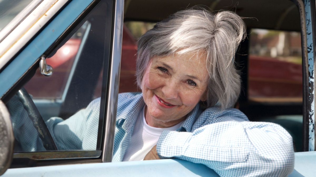 Happy senior out driving the old car.