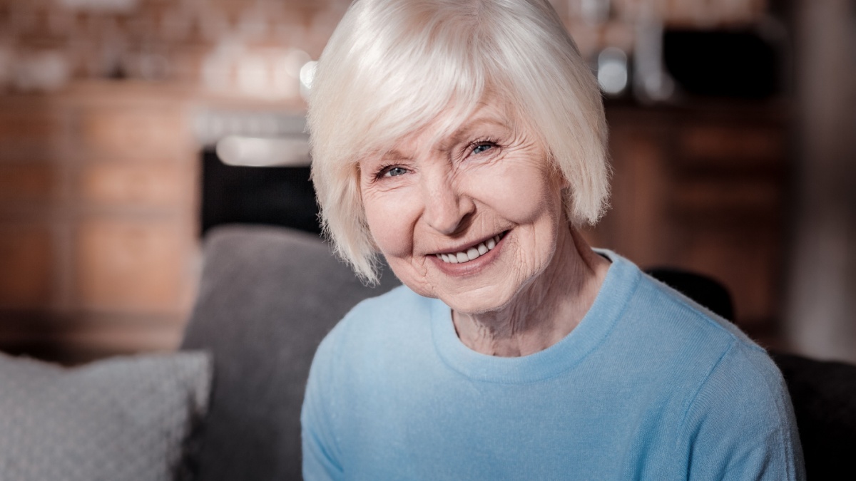 Sincere emotions. Charming female person keeping smile on her face while posing on camera.