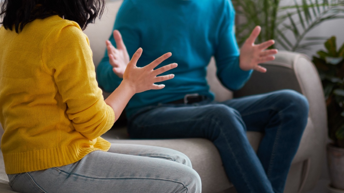 sad wife and husband, angry couple in bedroom. unhappy couple concept. husband and wife are sitting on the couch have an emotional conversation.