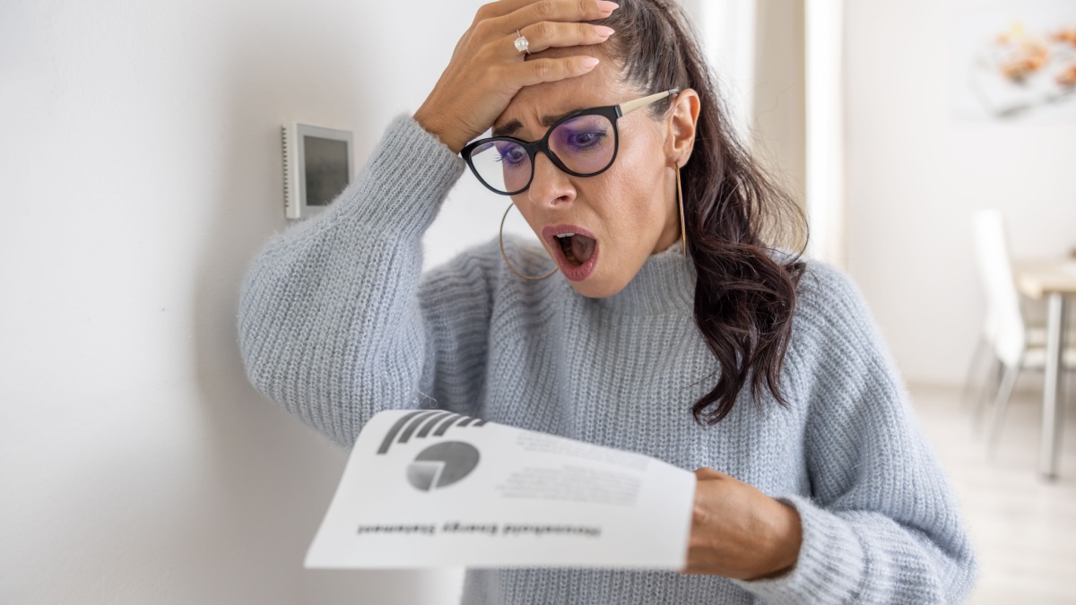 Woman is shocked from the rising energy costs and the bill she received for heat and electricity for her household.