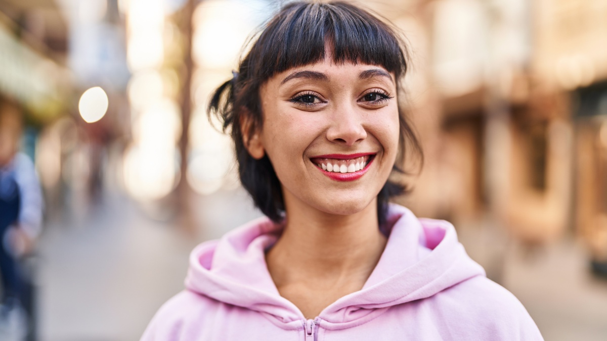 Young woman smiling confident standing at street.