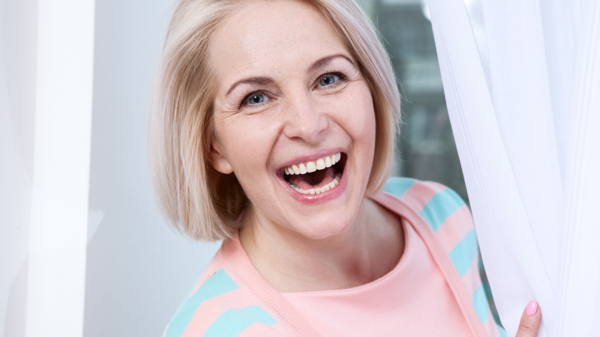 Smiling attractive middle aged woman relaxing at home. The beautiful face close up.