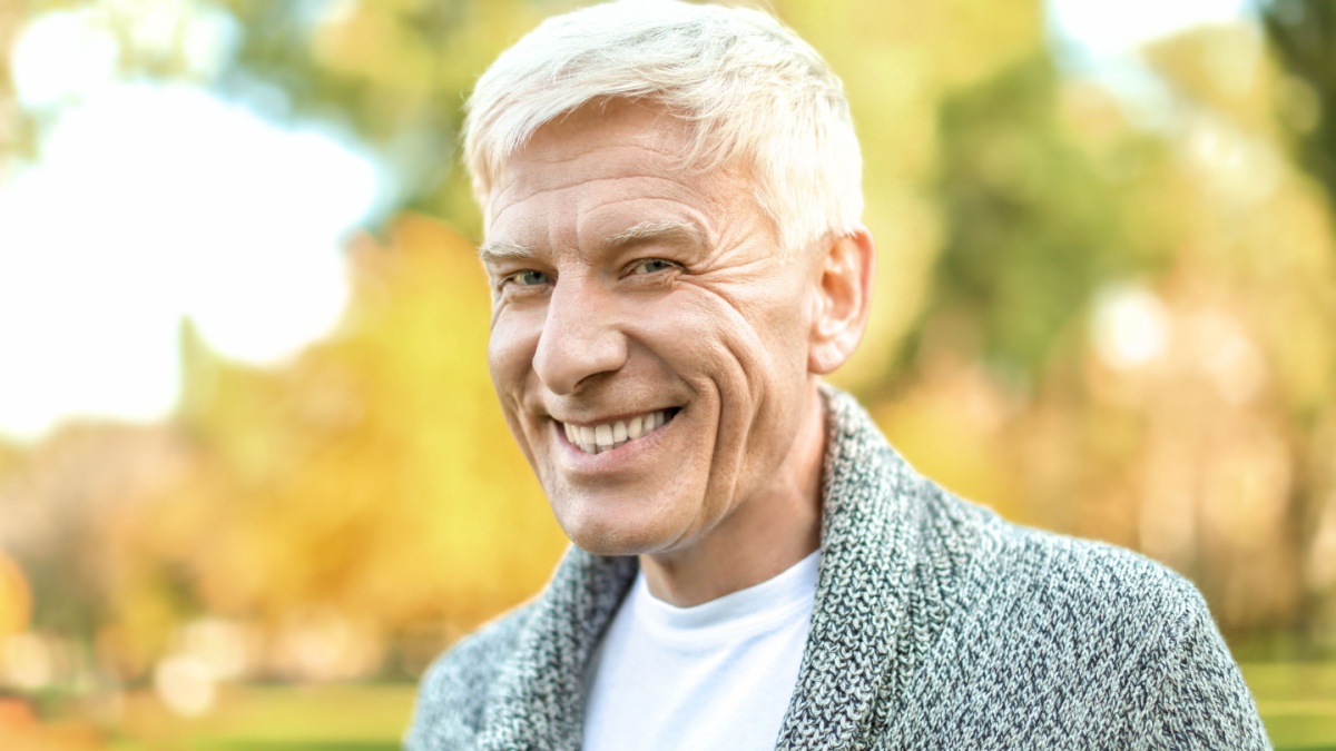 Stylish mature man in autumn park.