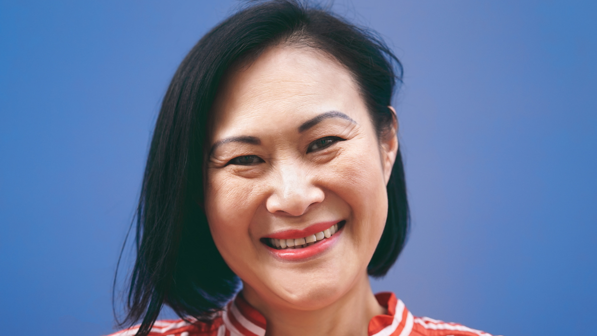 10 Ways Retired Boomers Can Live on a Budget This Summer, Senior Asian woman portrait against blue background - Smiling Chinese female having fun posing in front of camera - Mature people lifestyle concept.