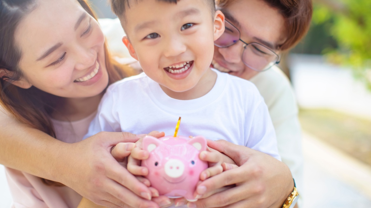 happy parent holding piggy bank and teaching son save money.