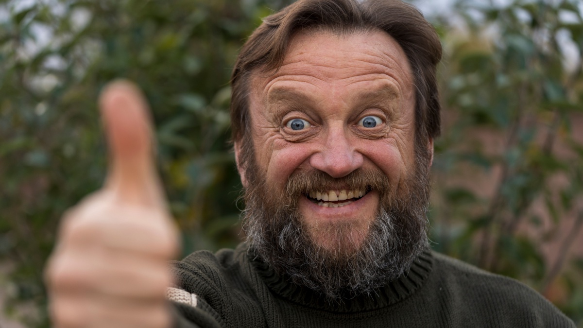 Portrait of cheerful optimist senior man looking at camera with thumb up.