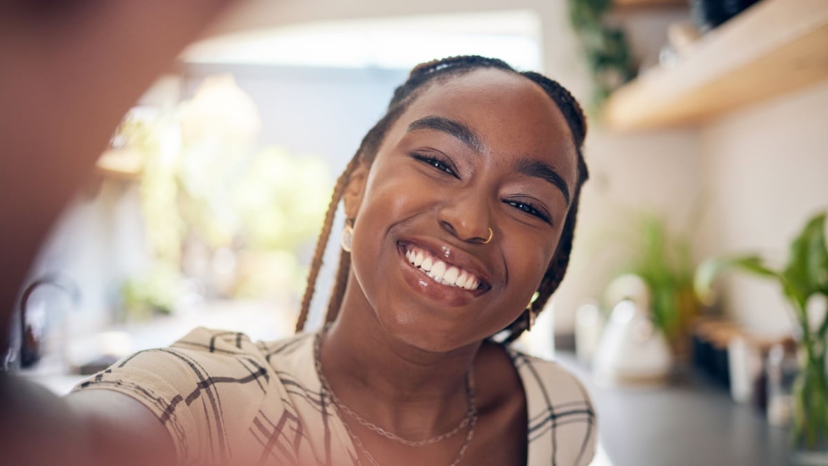 Smile, selfie and face of a young black woman for social media, happiness or positive attitude.