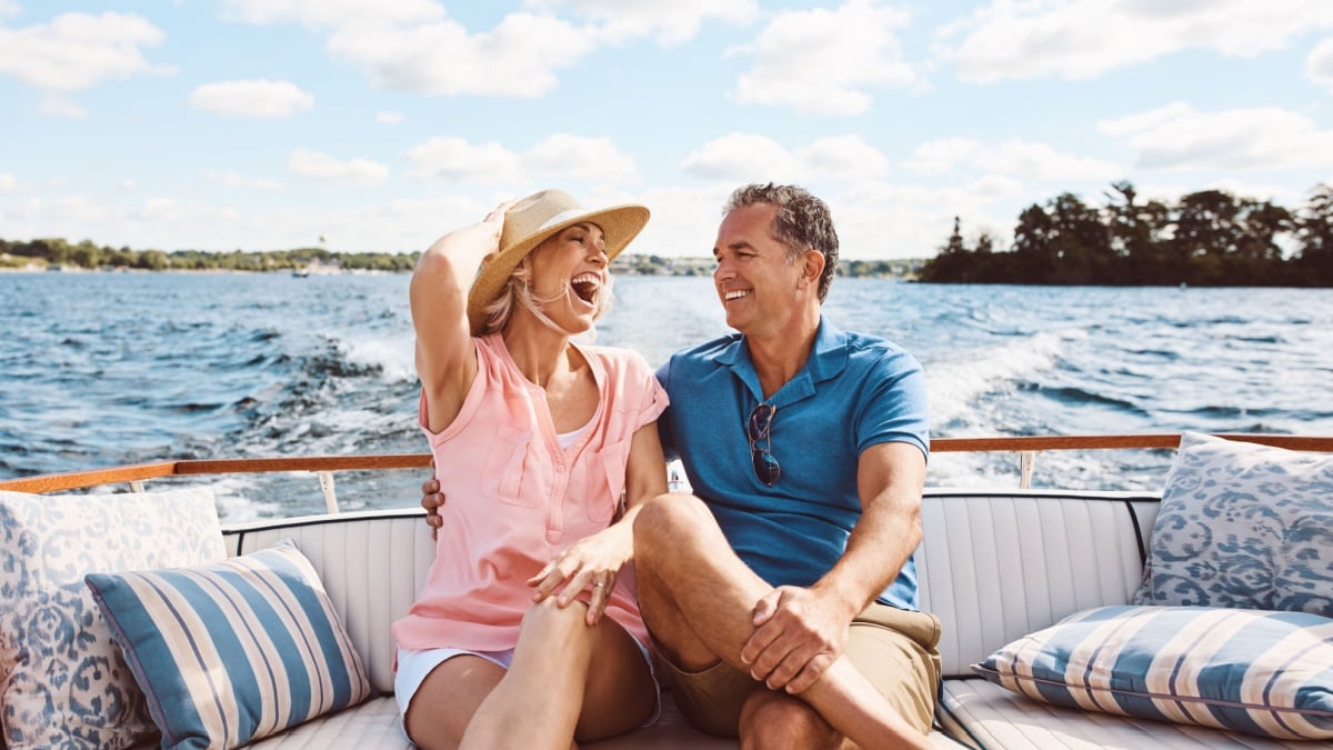 Laughing, happy couple and on a boat for retirement travel, summer freedom and holiday in Bali.