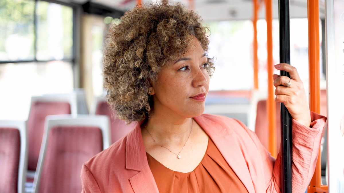 Mature woman traveling to work by a bus.
