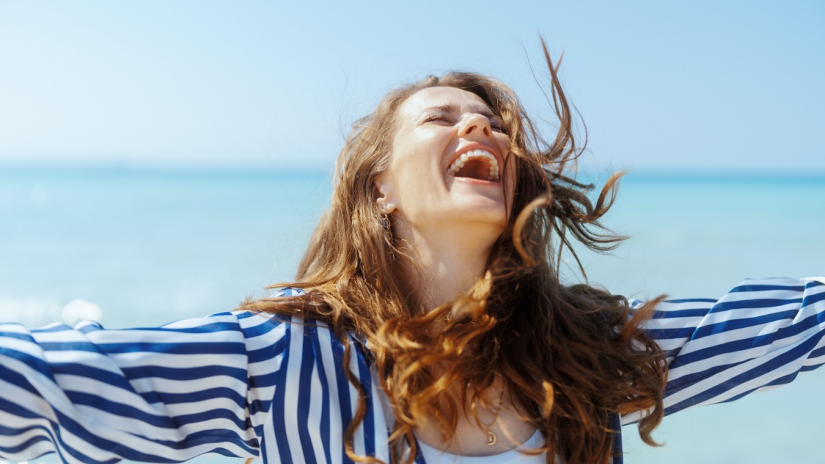 smiling modern woman on the seashore having fun time.