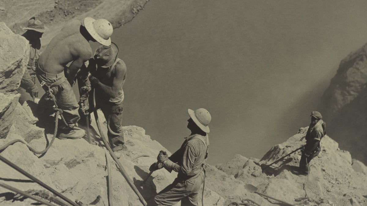 Workers at Boulder Dam site in 1934. They are high scalers drilling on canyon walls above the Colorado River.