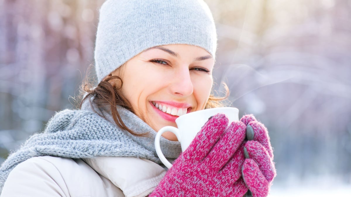 Beautiful Happy Smiling Winter Woman with Mug Outdoor. Laughing Girl Outdoors with Hot Drink.