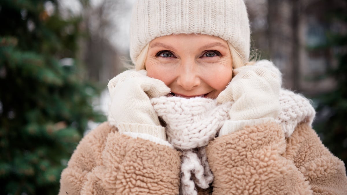 Photo of pretty flirty woman wear beige coat walking hiding comfortable knitted scarf outside urban city park.