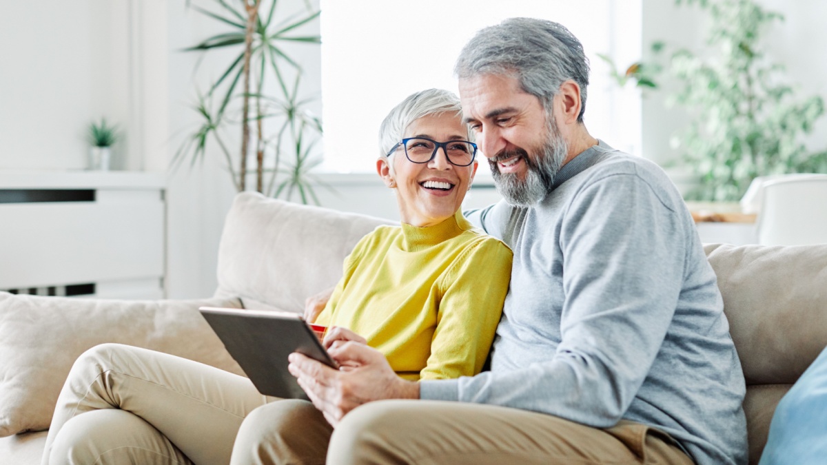 portrait of happy smiling senior couple using tablet at home.