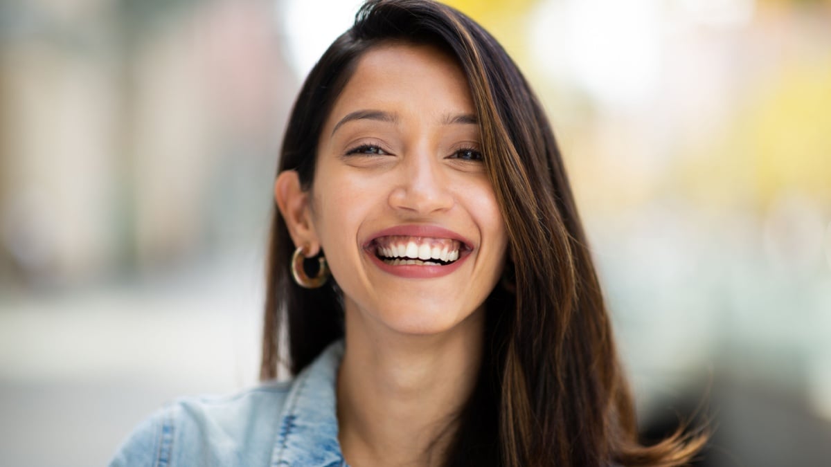 Close up front portrait beautiful woman laughing outdoors.
