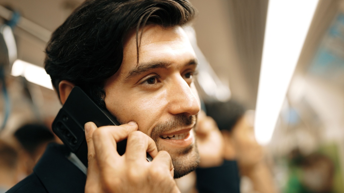 Closeup image of skilled business man face phone call to project manager in train with blurred background. Attractive caucasian investor talking to investor while standing at subway. Exultant.