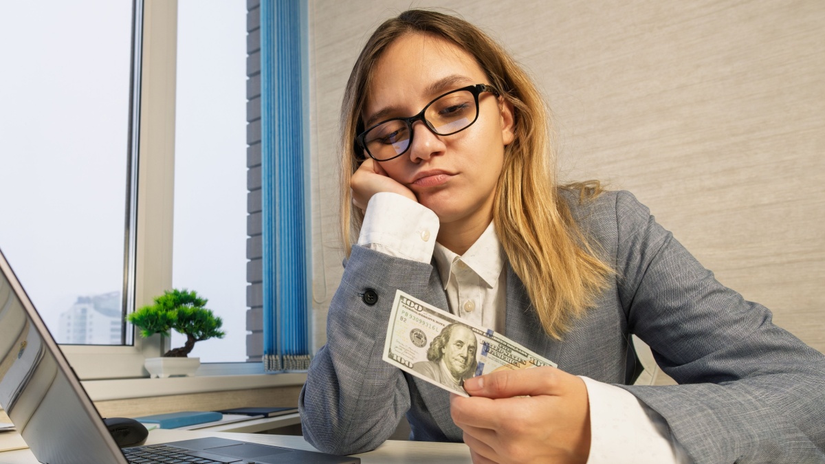 Caucasian woman counting cash insufficient amount of money. Financial crisis. Bankruptcy. Poverty and destitution. Female girl businesswoman sits at office. the accountant is unhappy with the profit.