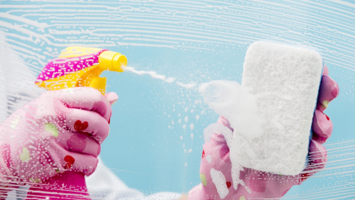 Cleaning - cleaning window pane with spray detergent, spring cleaning concept.