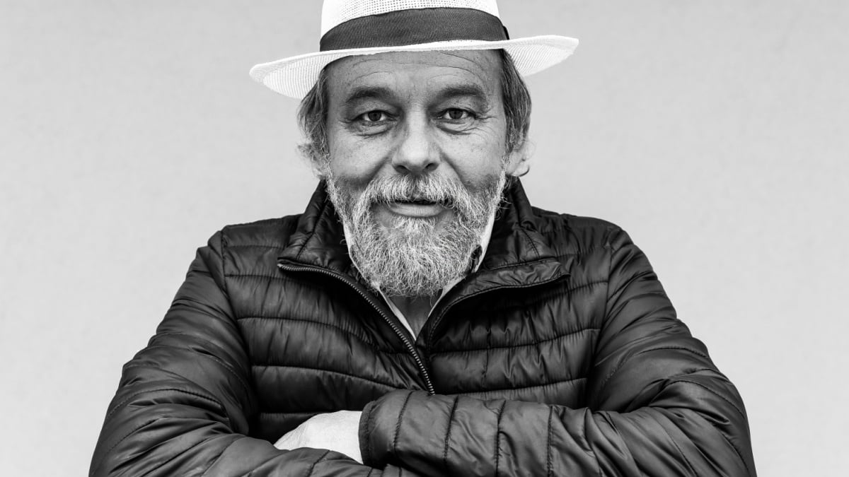 Portrait of a confident, handsome, mature man, pensioner, grandfather on the house wall background, black white photo.