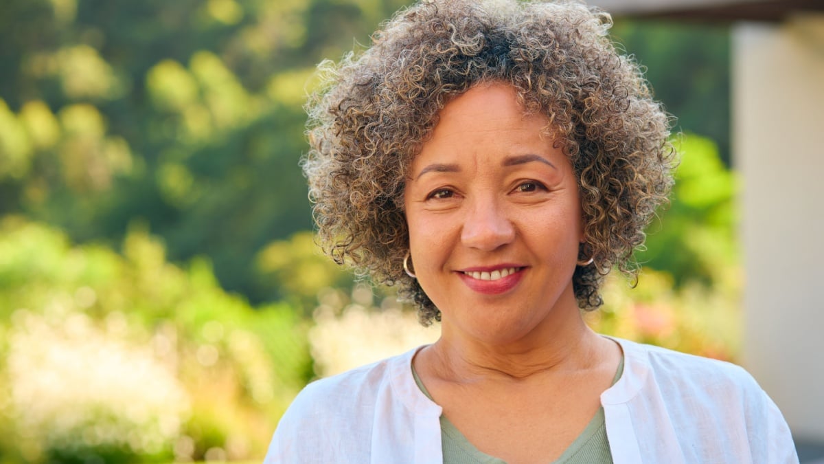Portrait Of Laughing And Smiling Mature Woman Standing Outdoors In Countryside.
