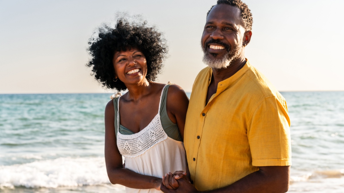 Beautiful mature black couple of lovers dating at the seaside - Married african middle-aged couple bonding and having fun outdoors, concepts about relationship, lifestyle and quality of life.