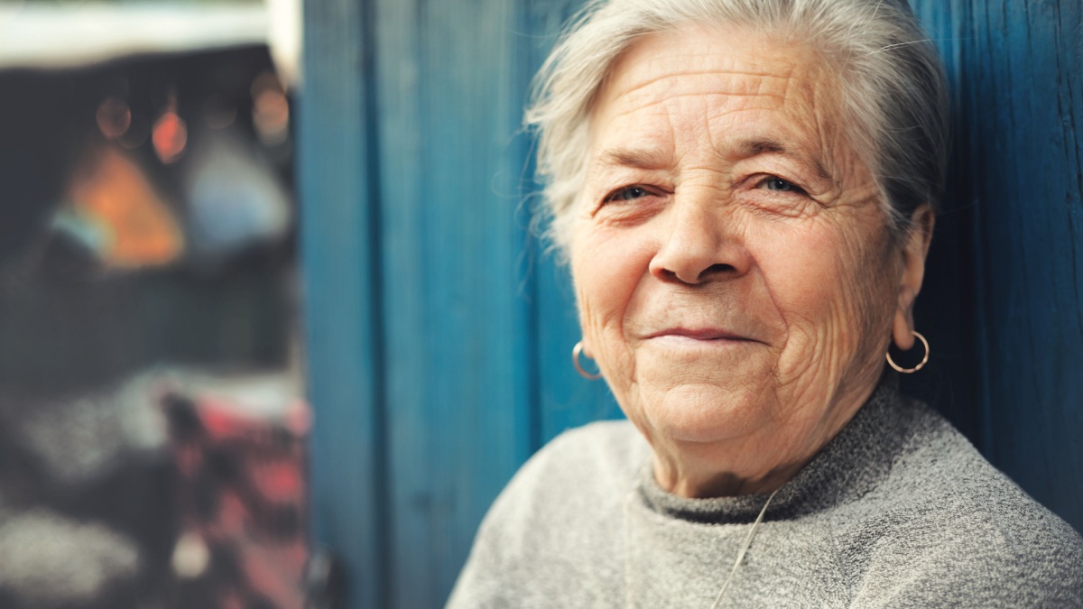 Happy old senior woman smiling outdoor portrait.