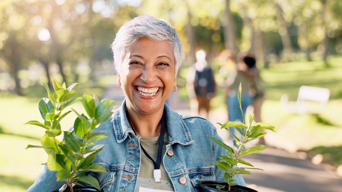 Volunteer, portrait or happy woman with plants at park for gardening, earth day or sustainability in nature. Ecology, face or mature person with tree for environment conservation or community service.