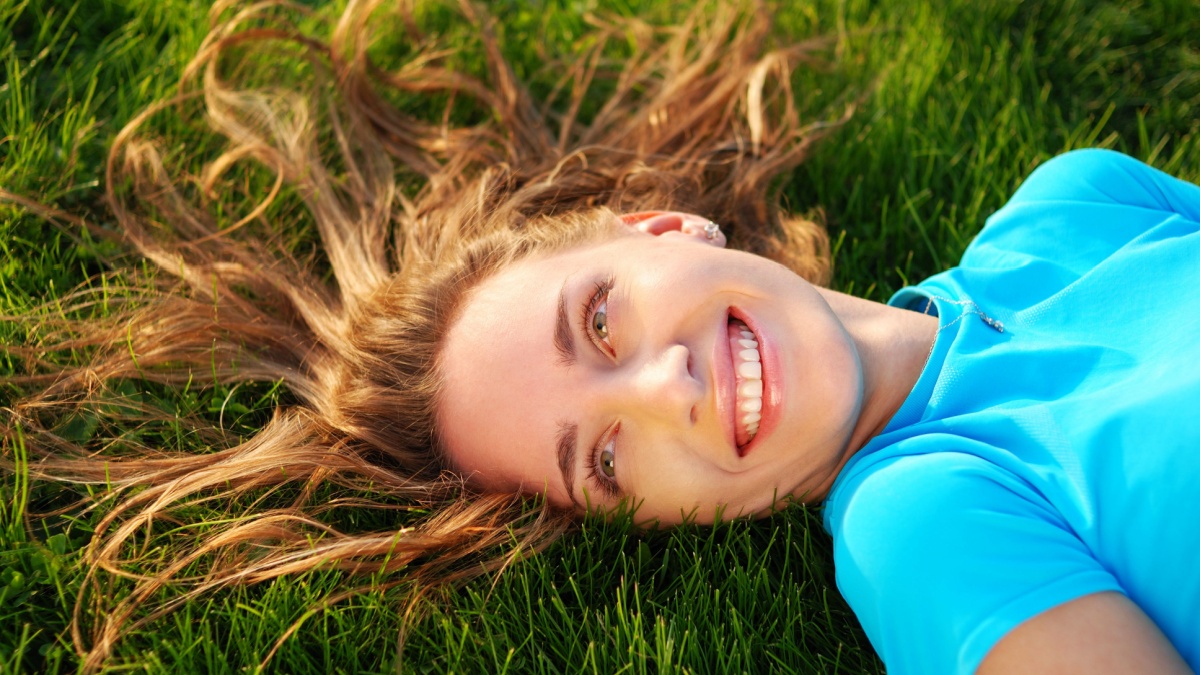 Girl laying on fresh green grass.