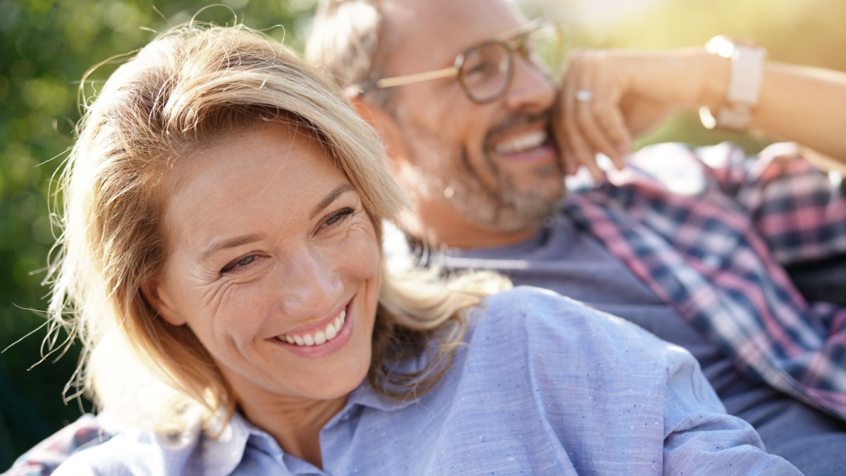 Portrait of mature couple relaxing in outdoor sofa.