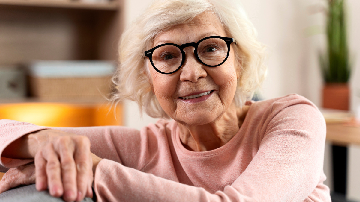 Smiling confident grandmother posing at home. Old senior woman looking at camera portrait. Happy mature woman smiling. Retirement people concept.