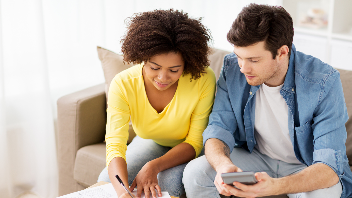 family budget, finances and people concept - couple with papers and calculator counting money at home.
