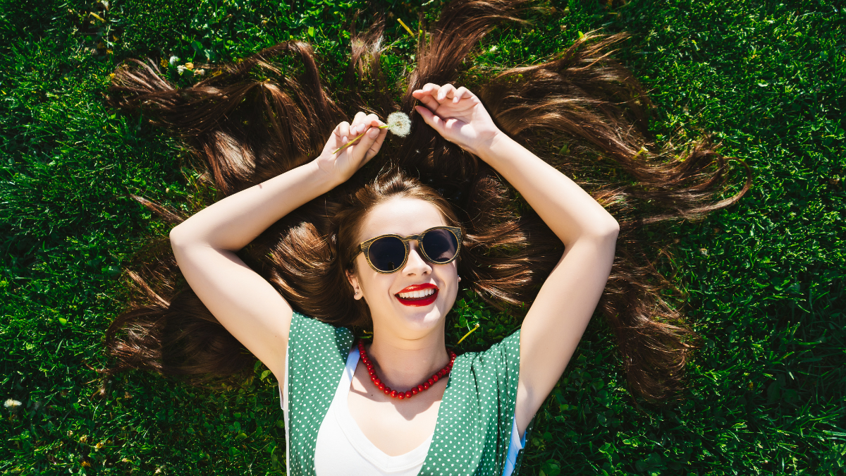 Surprised funny woman enjoying life on grass, happy smile ,relax on street.