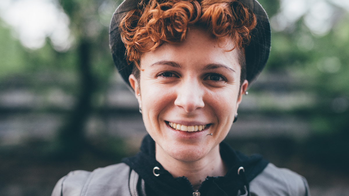 Portrait of young beautiful lesbian redhead woman outdoor looking at camera, smiling - happiness, serene, smiling concept.