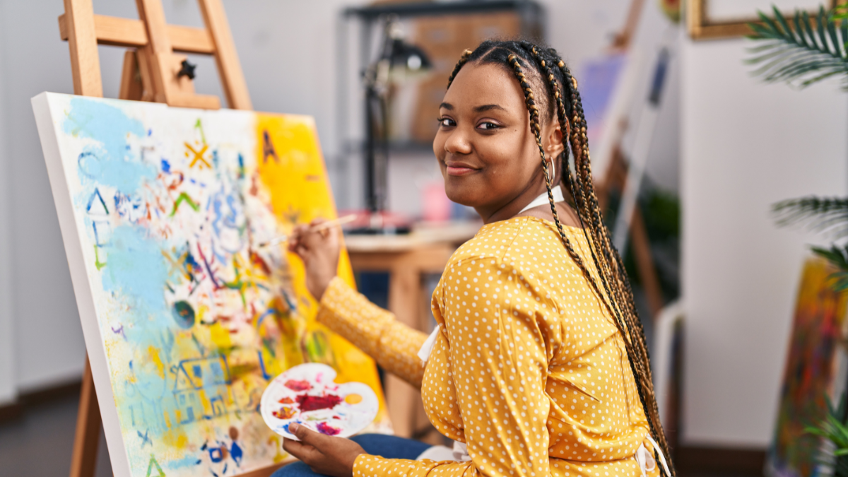 African american woman artist smiling confident drawing at art studio.
