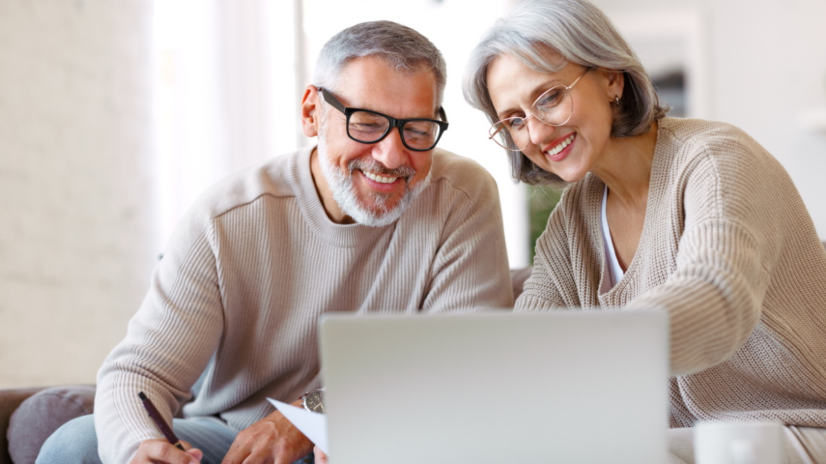 Smiling senior couple calculate expenses or planning budget together, reading notification letter with good news from bank , retired family husband and wife paying bills online on laptop.