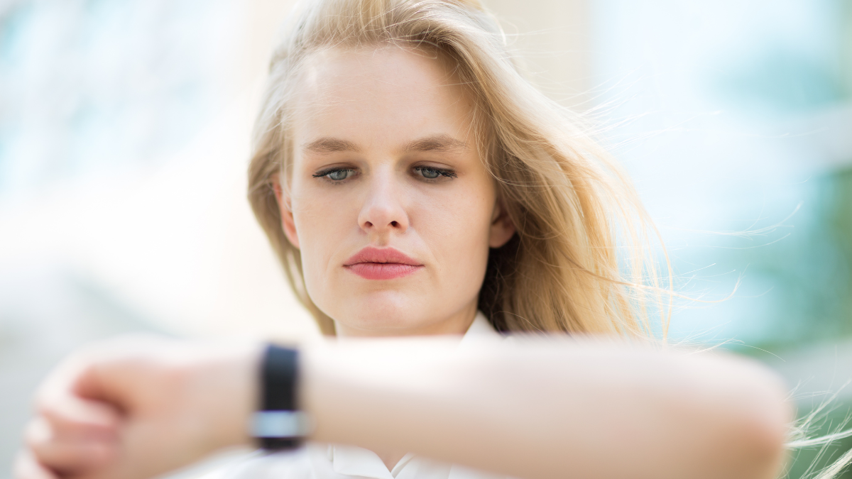 Young business woman checking the time on her watch.