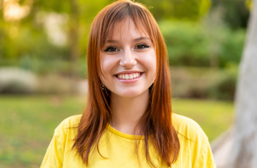 Young pretty redhead woman at outdoors With happy expression.