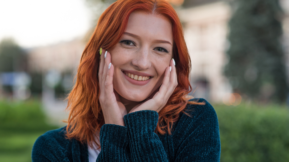 Portrait of a young, beautiful and attractive redhead Caucasian girl with freckles. Girl posing walking through the city.