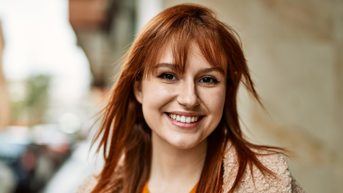 Young redhead girl smiling happy standing at the city.