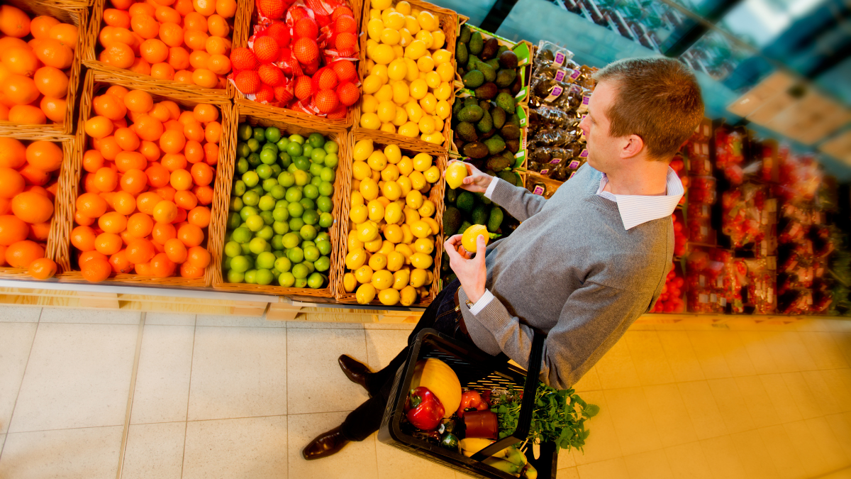 A man buying fruit in a grocery store.