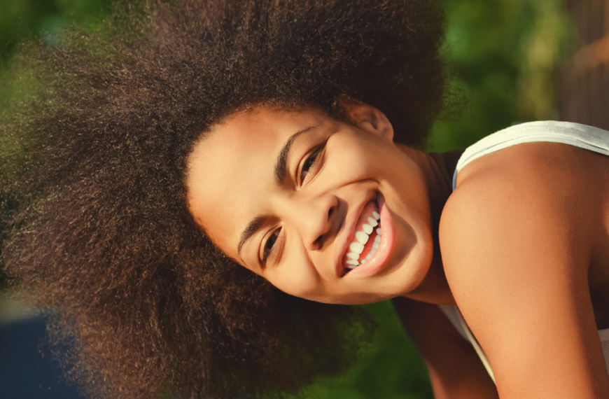 young happy and pretty afro wooman closeup portrait on natural background.