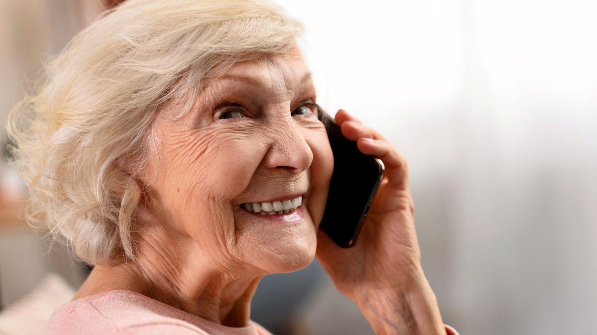 Senior lady grandmother talking smartphone communicating with friends, grandchildren, colleagues at home. Technologies and retirement people concept .