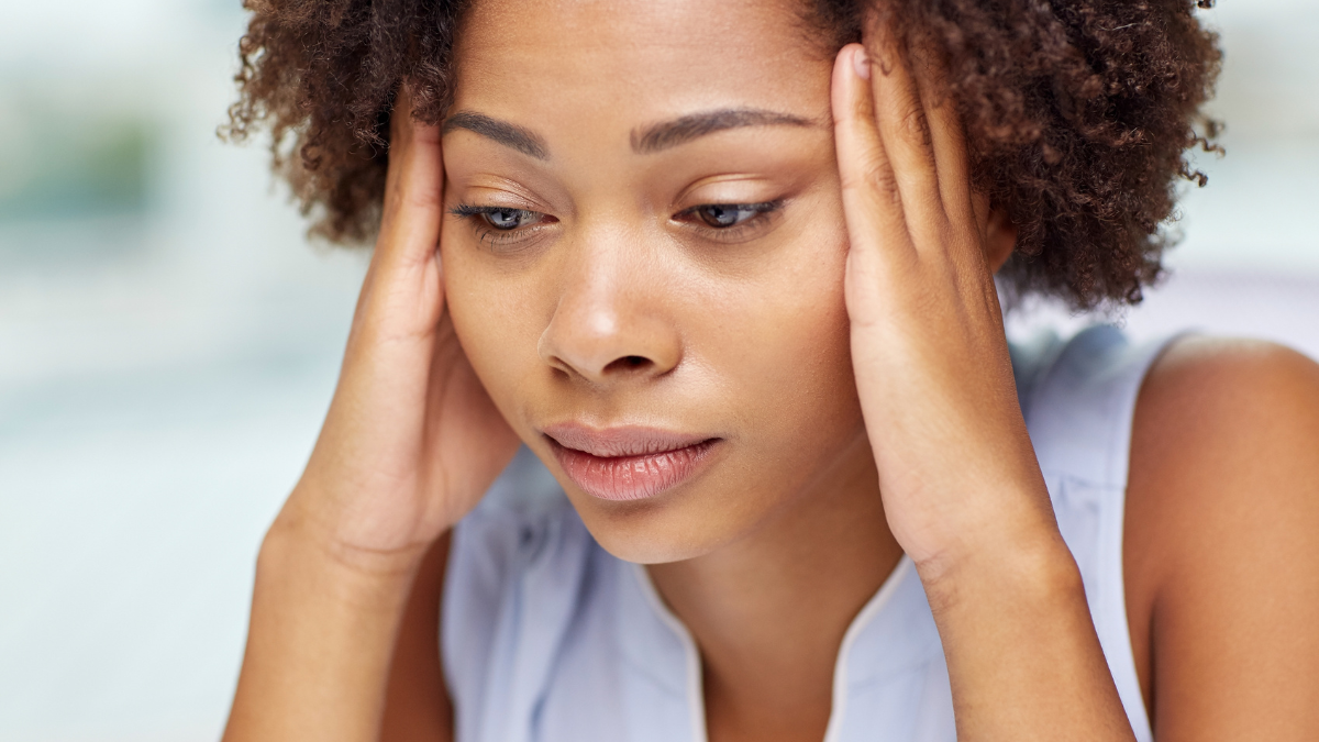 people, emotions, stress and health care concept - unhappy african american young woman touching her head and suffering from headache.