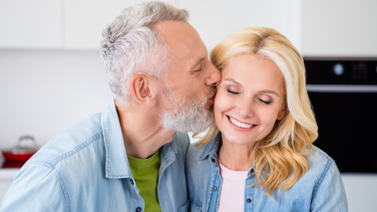 Portrait of lovely cute dreamy couple mature people enjoy weekend free time affectionate husband kiss beautiful wife.