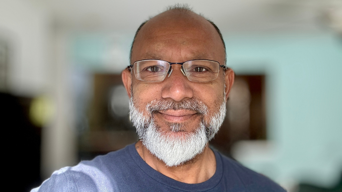 Bald old asian male with gray beard wearing prescription glasses posing for a selfie.
