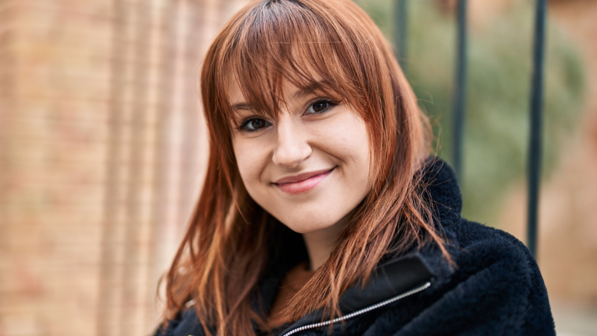Young woman smiling confident standing at street.