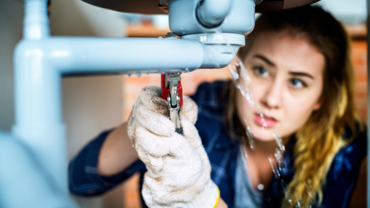 Woman fixing kitchen sink.
