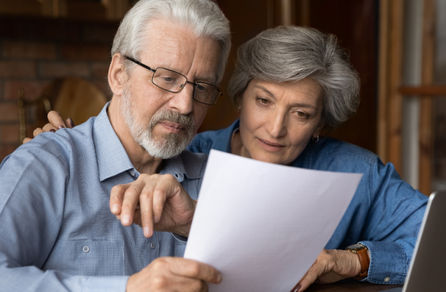 Every paper needs attention. Interested old age married couple do paperwork engaged in reading document. Focused retired spouses study terms conditions of insurance policy think on signing agreement.