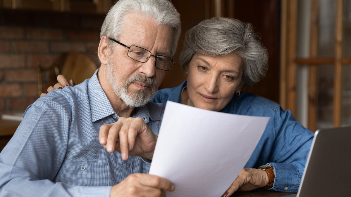 Every paper needs attention. Interested old age married couple do paperwork engaged in reading document. Focused retired spouses study terms conditions of insurance policy think on signing agreement.